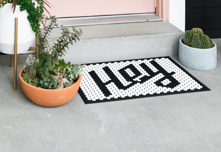 doormat with the text `hey` near the house